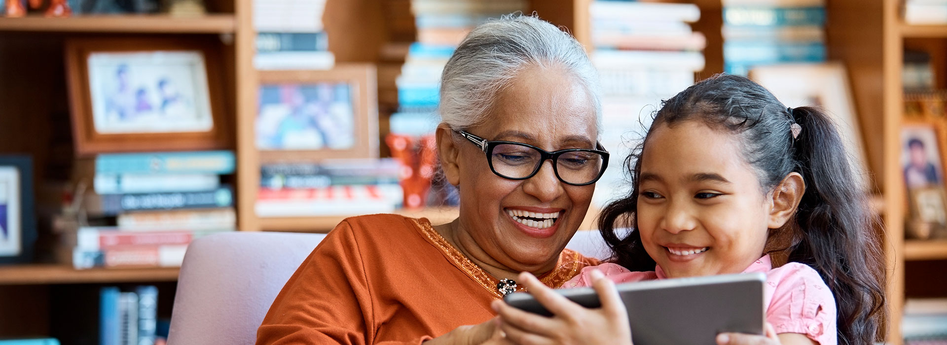 Photo of grandmother with granddaughter using a tablet