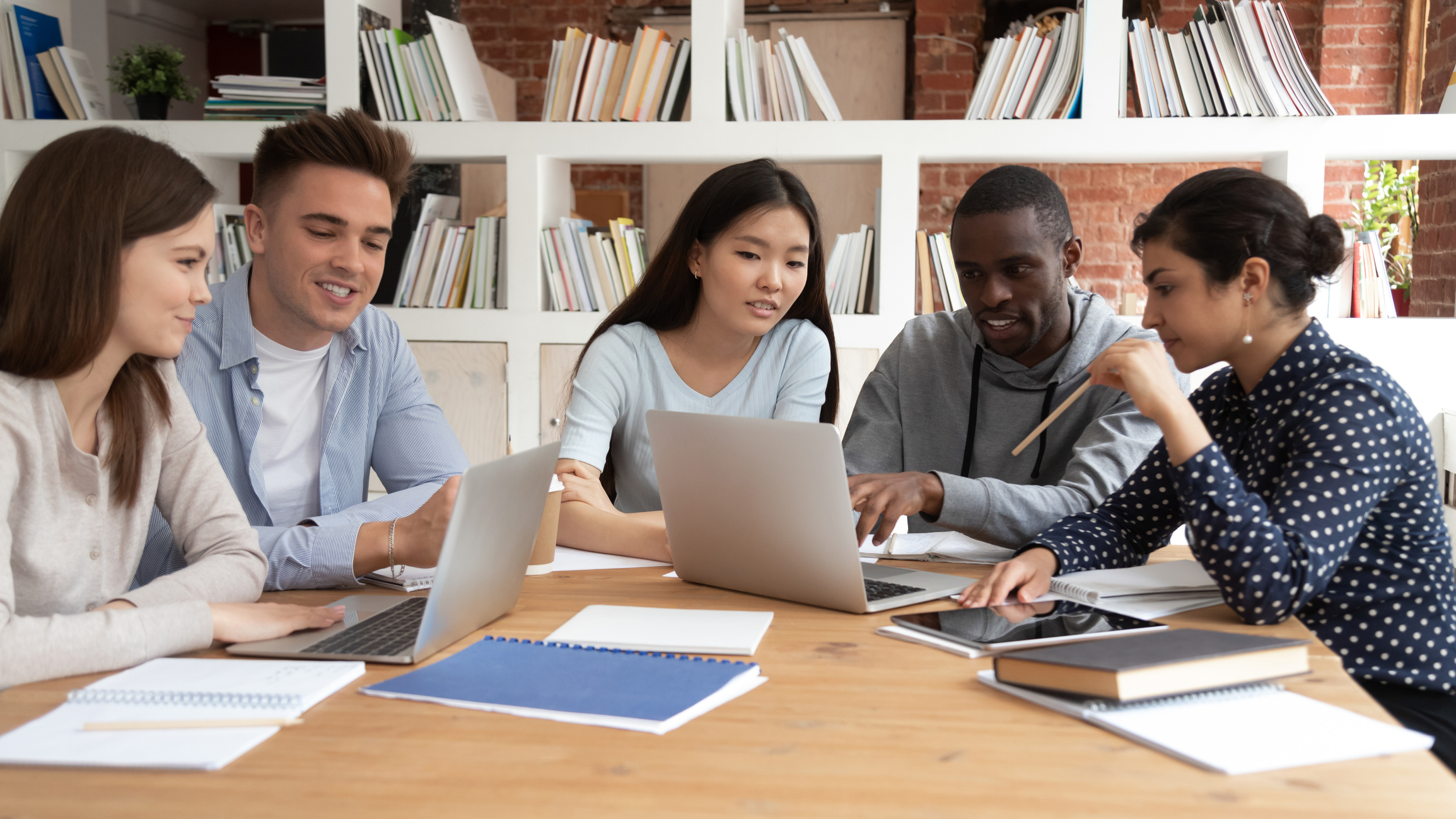 Photo of diverse graduate students around the table having discussions