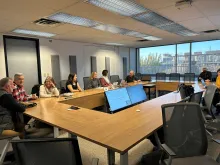 Photo of Integrated Curriculum facilitators in a boardroom talking to each other