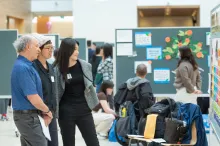Photo of students and health mentors looking at poster presentations