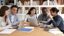 Photo of diverse graduate students around the table having discussions