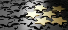 Photo of five gold stars against a backdrop of many grey stars