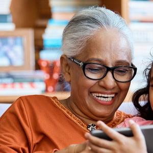 Photo of grandmother with granddaughter using a tablet