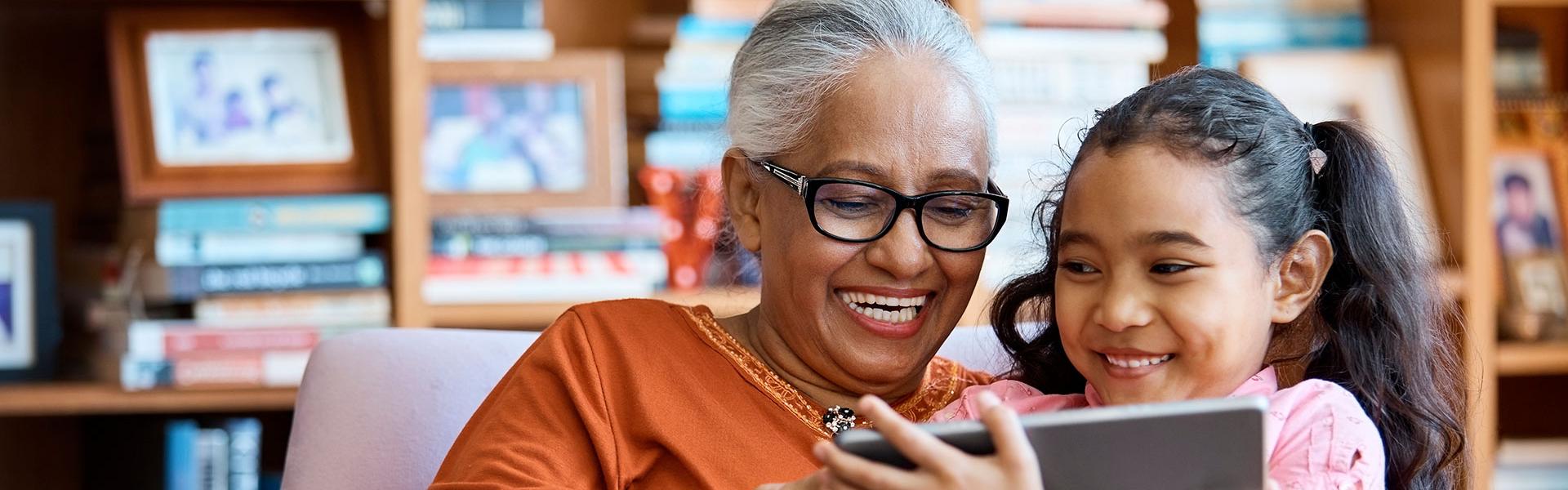 Photo of grandmother with granddaughter using a tablet